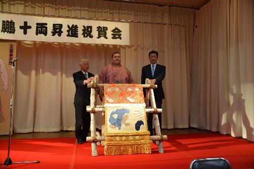 王鵬十両昇進祝賀会にて、化粧まわしを前に、徳永町長、王鵬、竹森会長で記念写真