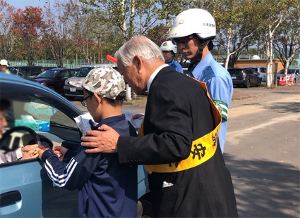 旗の波街頭啓発運動でドライバーに小学生と啓発品を配布する徳永町長