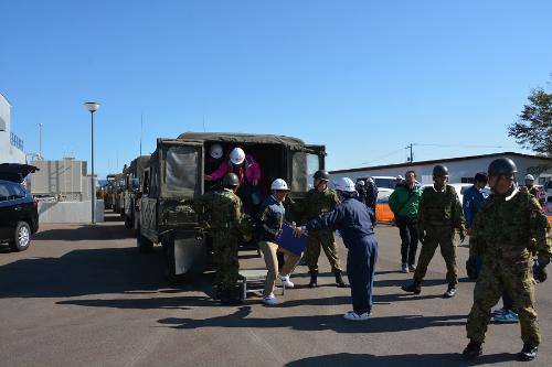 自衛隊車輌で避難してきた住民を誘導する町職員