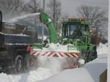 ダンプカーに雪を除雪している除雪車