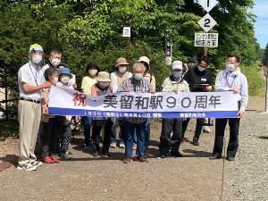 美留和駅90周年の横断幕を掲げて記念写真